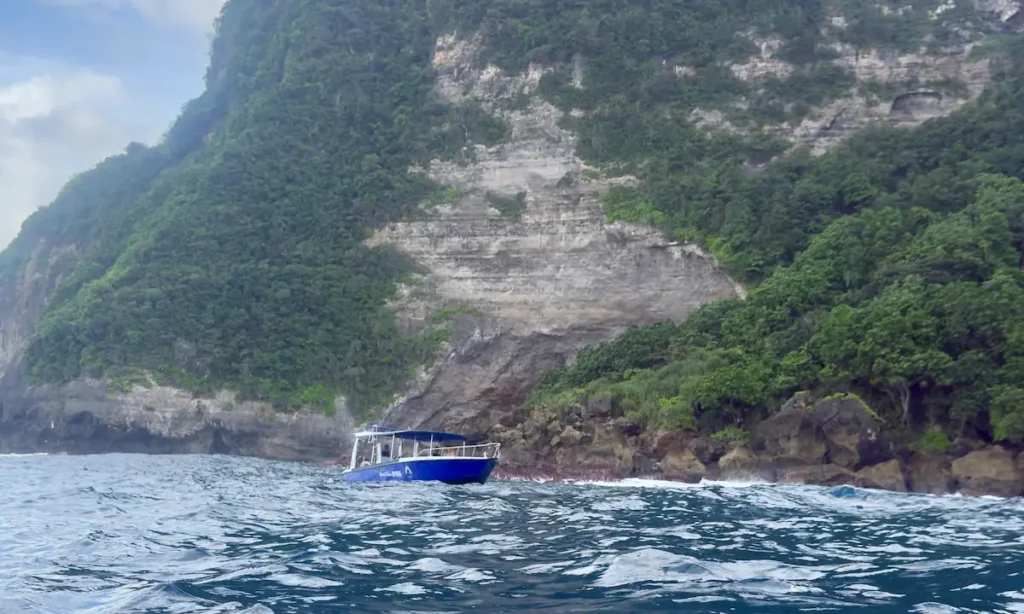 Barco en aguas rodeado de montañas en Nusa Penida