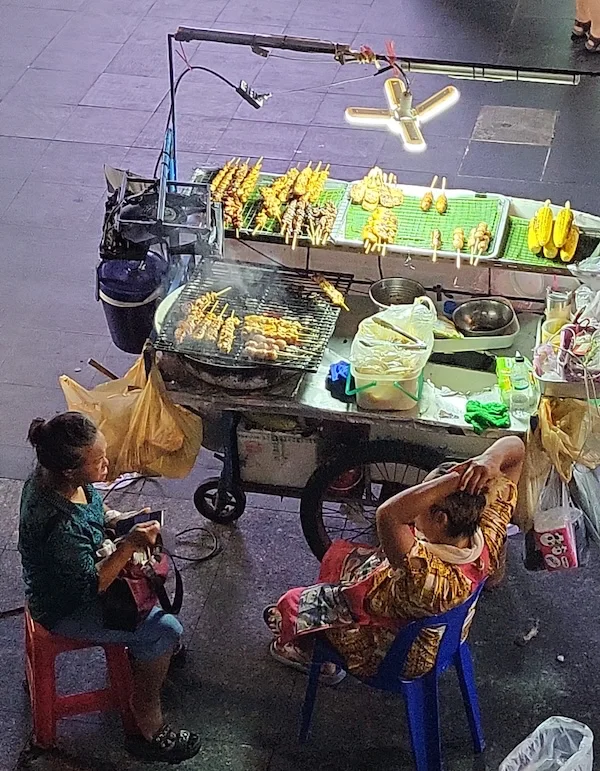 Asando mazorcas en el medio de una calle