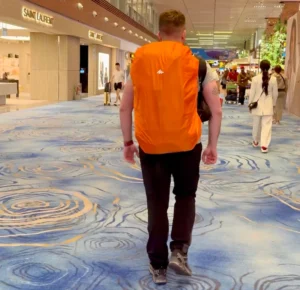 Pablo en un aeropuerto con la funda de su mochila de viaje