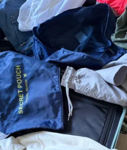 Organizadores de ropa en una maleta con mucha ropa desordenada alrededor